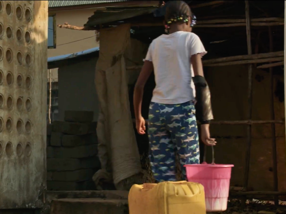 Khadijatu Bangura carrying a bucket of water Cover Image