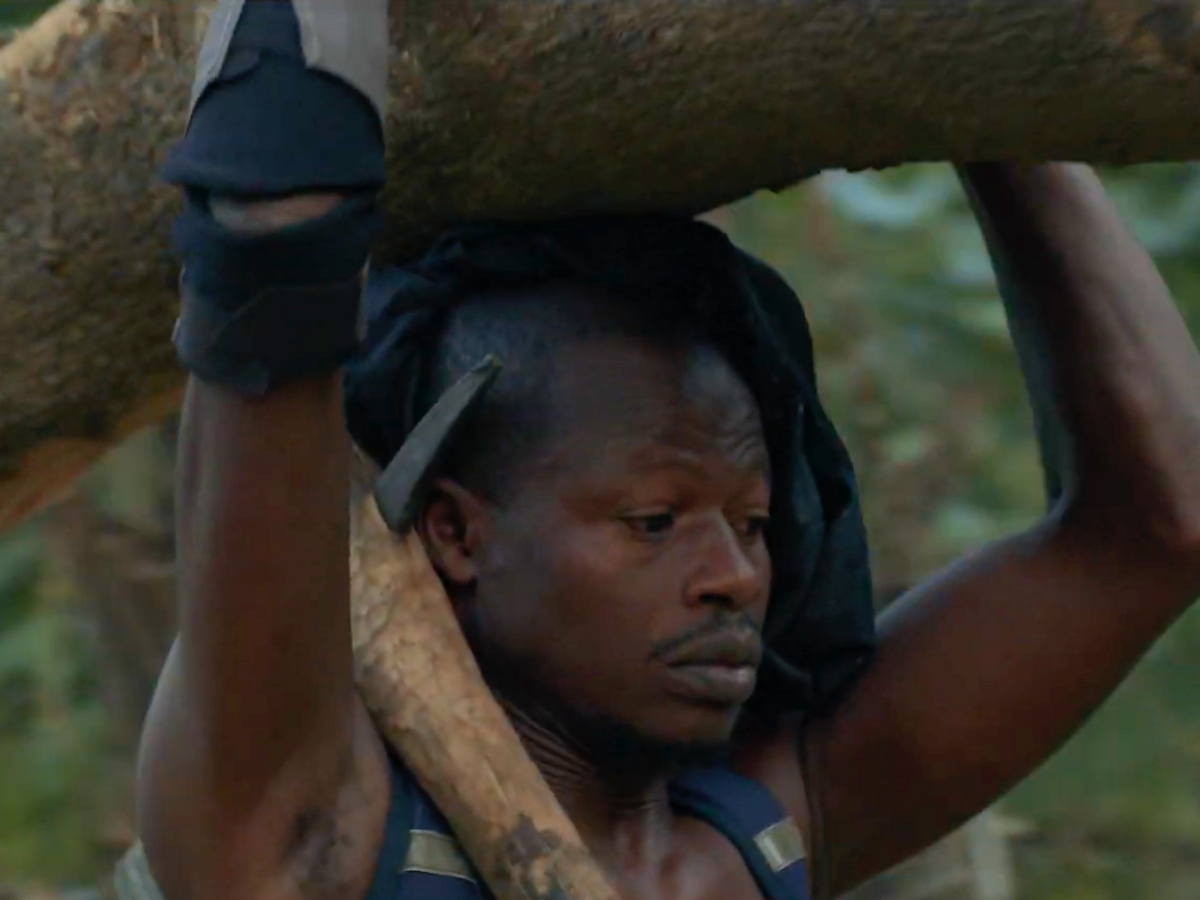 Santos lifting a log over his head Cover Image