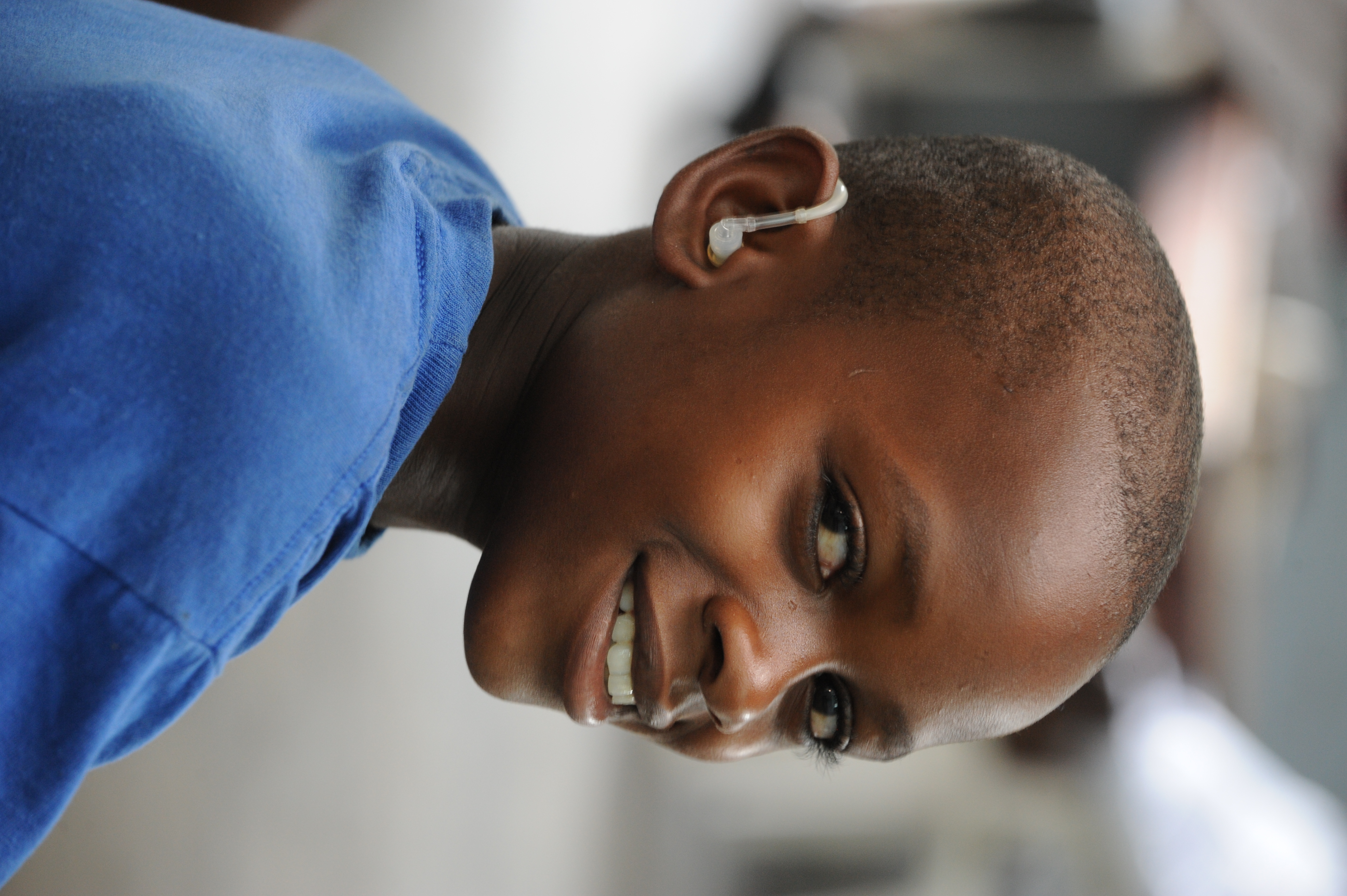 Black boy using a hearing aid. Cover Image