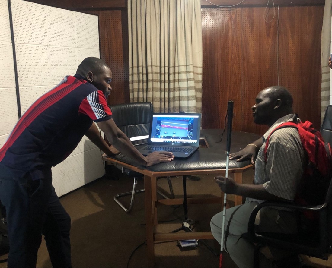 An image of Andrew with his co-commentator in a recordeing studio with a laptop on the table in front of them, commentating on the Tokyo Paralymic Games Cover Image