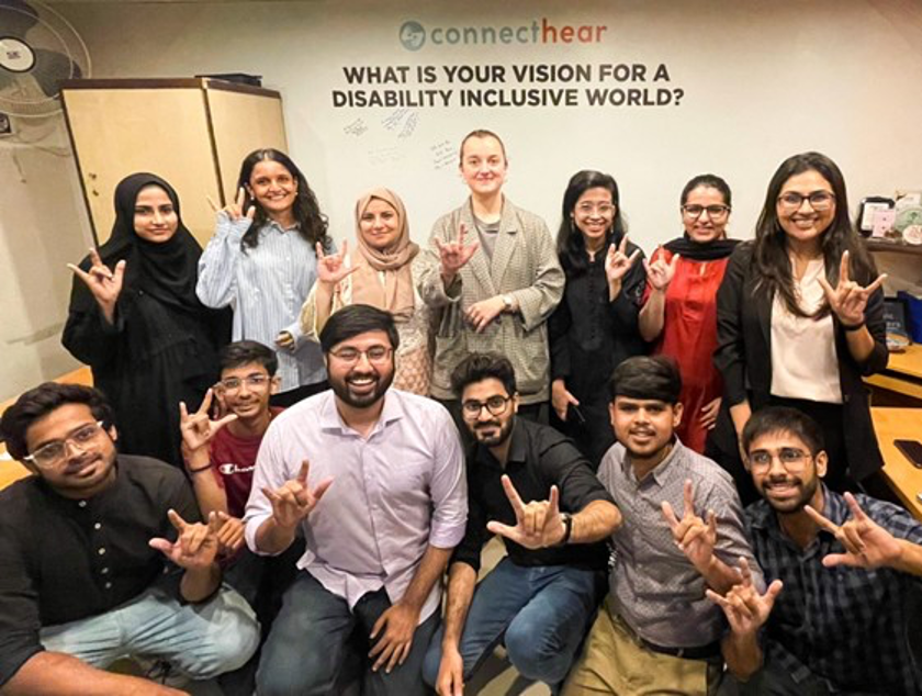 Maryam and Pollyana with the ConnectHear team signing "Love" in Pakistani Sign Language