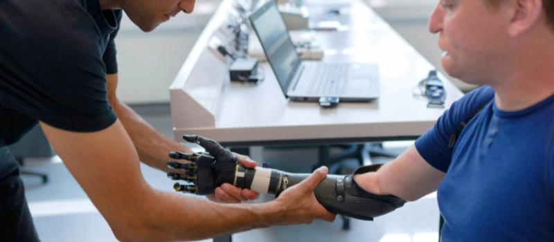 person fitting a prosthetic arm onto another person