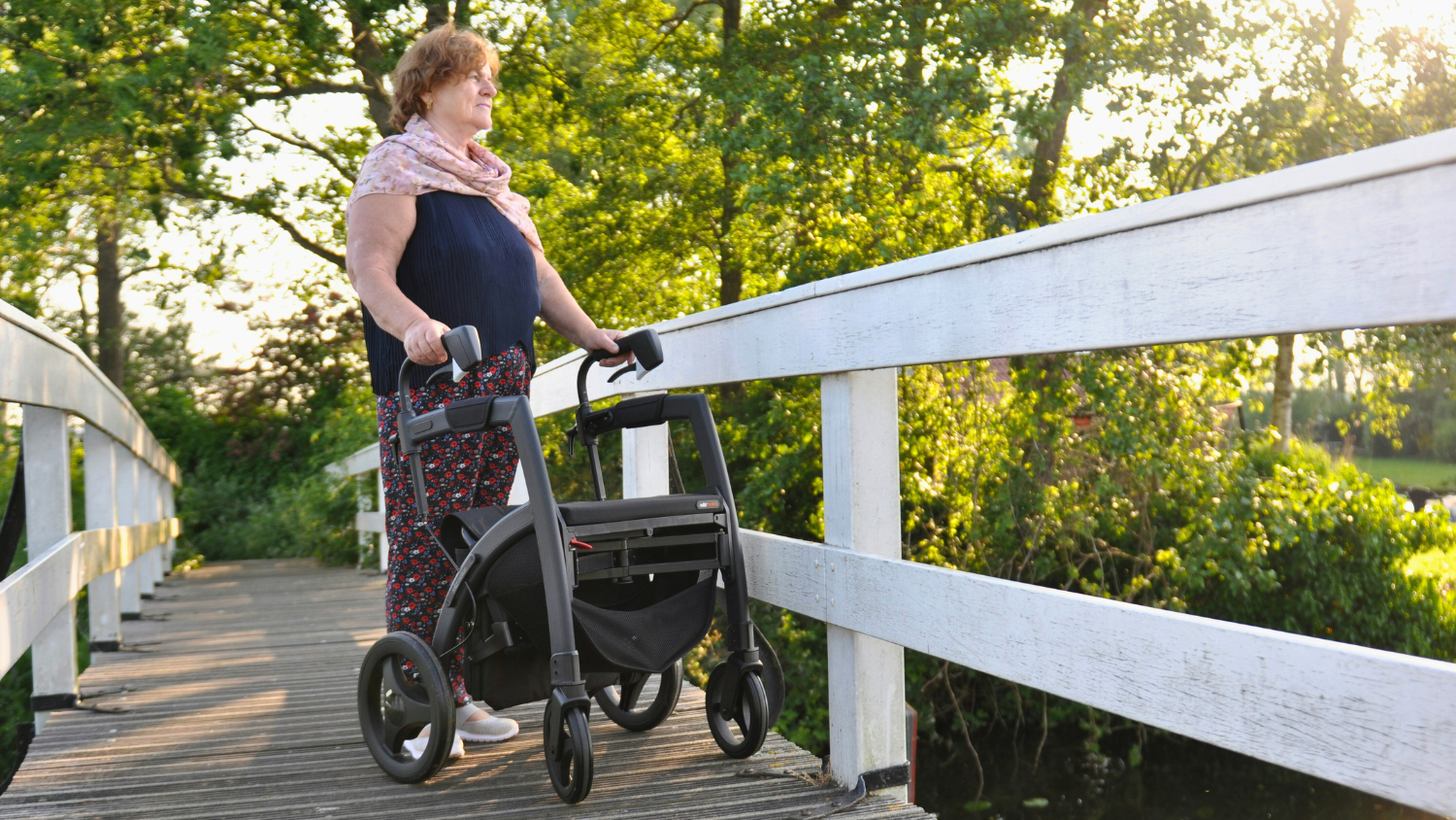 person with a mobility aid standing on a bridge 