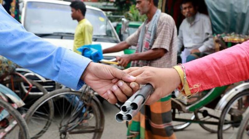 Two persons holding hands with an AT device 