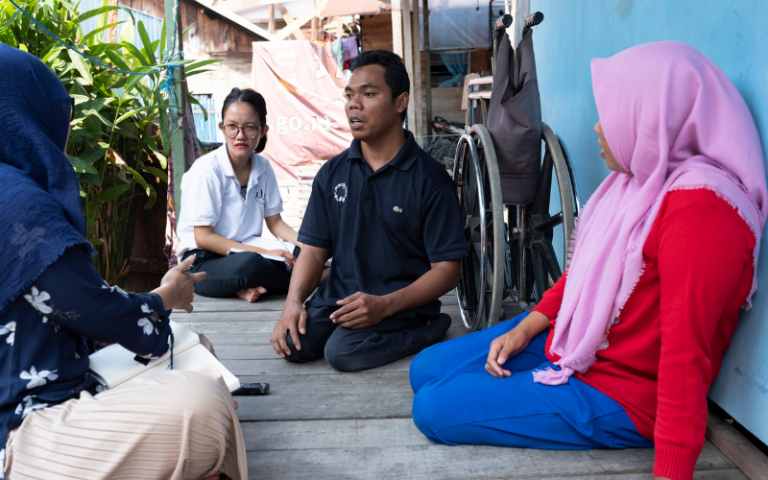 A researcher speaking to community members