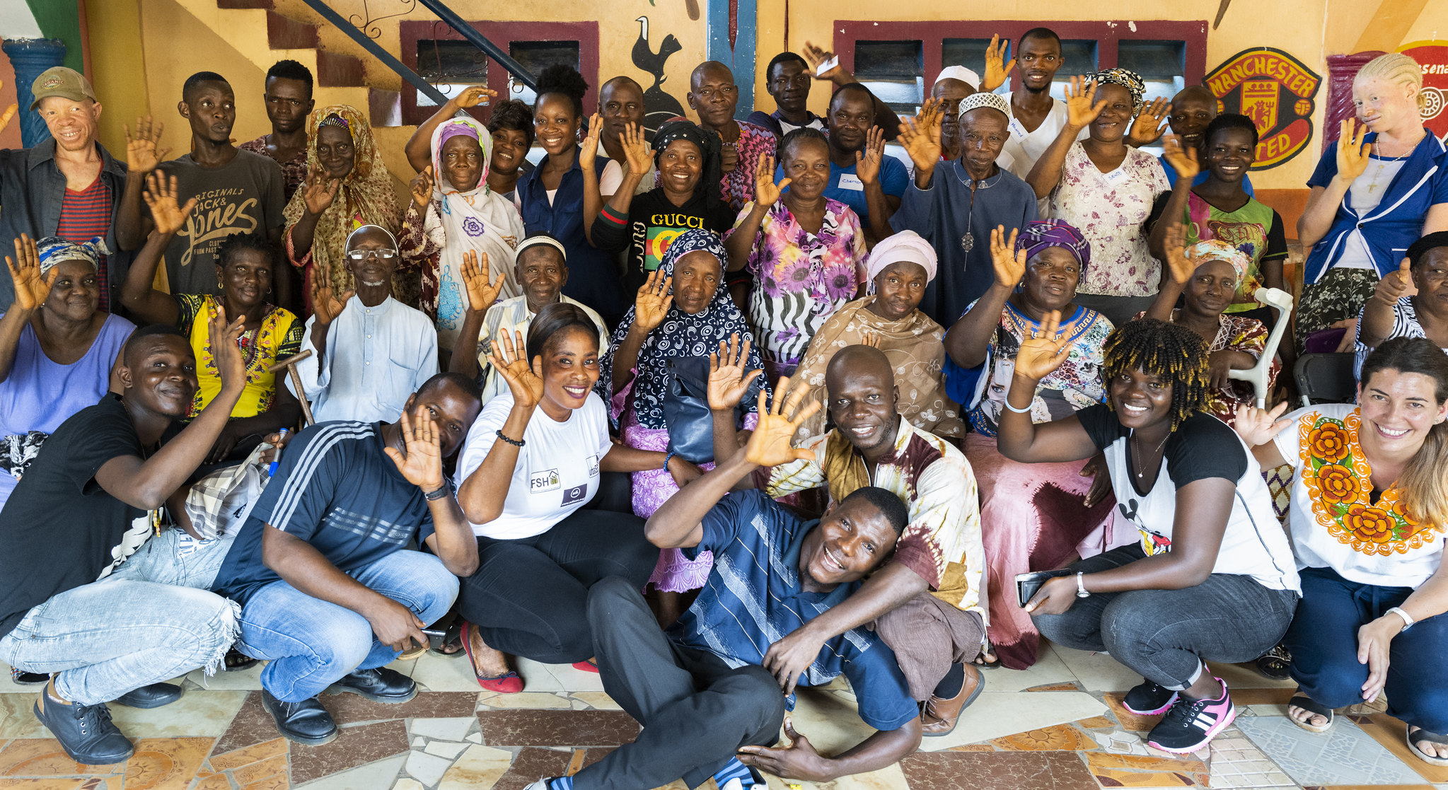 A group of people waving and smiling