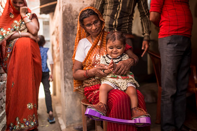 mother holding a child with the corrective assistive technology on her feet