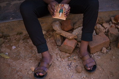 Photograph of Quraish holding a picture of himself as a child in plaster