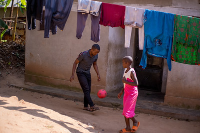 Photograph of Quraish kicking a ball outside with another person