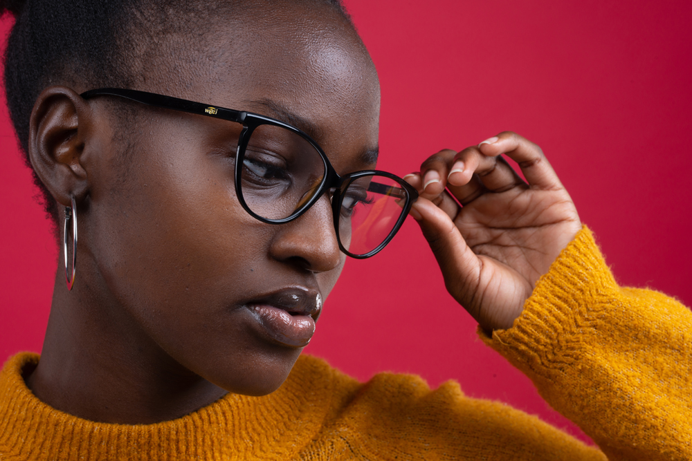 African women wearing fashionable eyeglasses and bright jumper in photoshoot