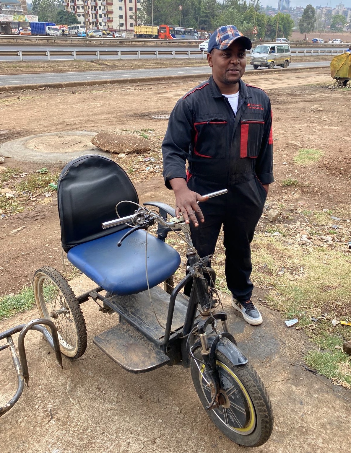 Lincon standing next to his first electric wheelchair prototype.