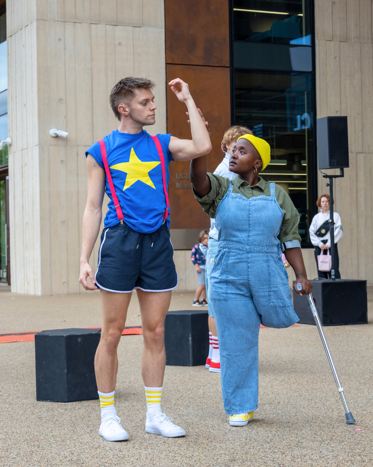 Two dancers, one with a crutch and one without. The dancer with a crutch is holding the forearm of the other dancer. Cover Image