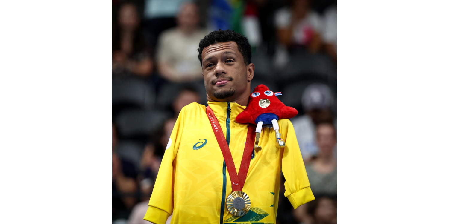 Gabrielzinho with one of his gold medals and Olympic mascot phryges on his shoulder.