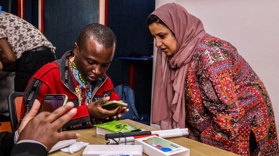 Maryam and a participant in our research working together to use a mobile phone as a form of AT.